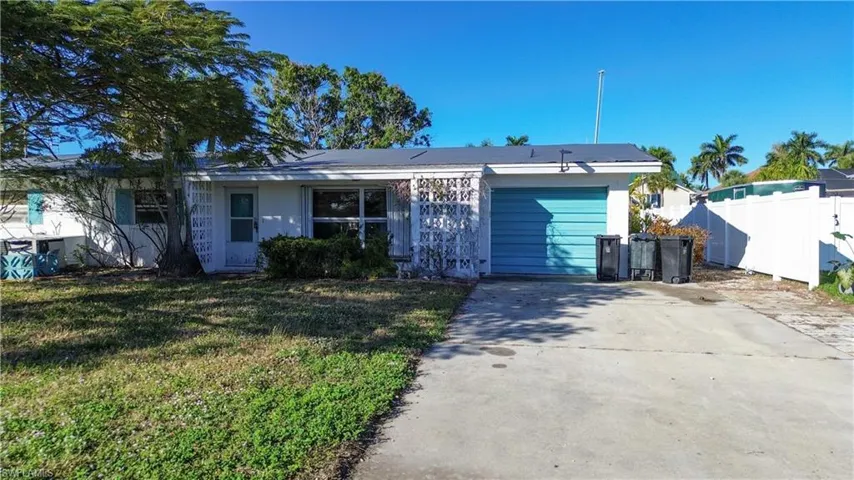 View of front of property with concrete driveway and an attached garage