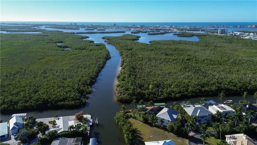Aerial view of a nearby body of water and a heavily wooded area