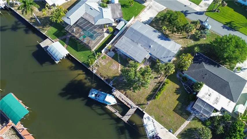 Aerial view of property and surrounding area featuring a nearby body of water and nearby suburban area