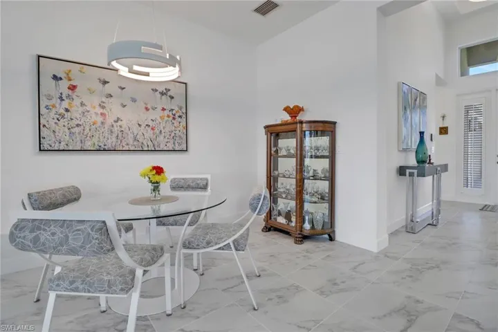 Tiled dining space featuring high vaulted ceiling