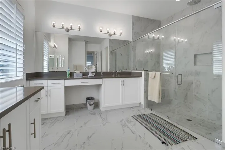 Bathroom with tile patterned flooring, an enclosed shower, and vanity