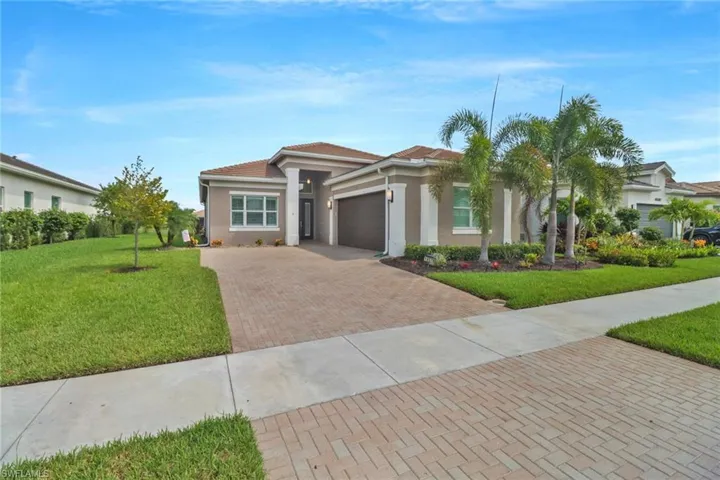 View of front of property featuring a front yard and a garage