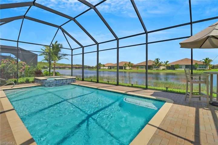 View of pool featuring an in ground hot tub, a patio, and a lanai
