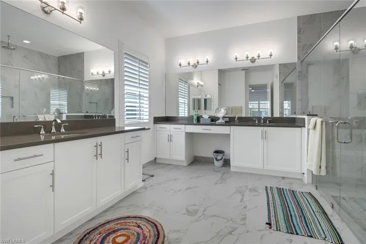 Bathroom featuring tile patterned flooring, an enclosed shower, and vanity