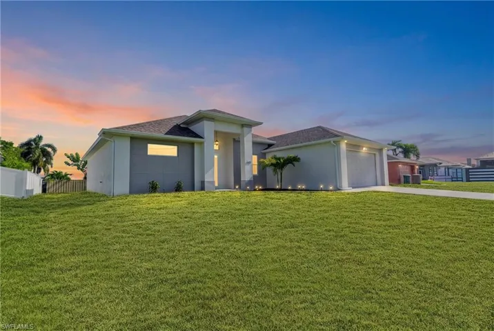Modern exterior with a light-toned stucco finish, prominent front entryway, an attached garage, and a spacious front lawn