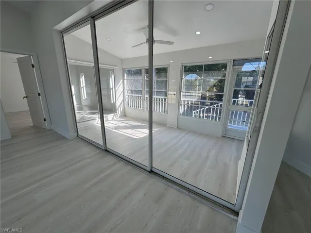 Doorway featuring a ceiling fan, wood finished floors, and lofted ceiling