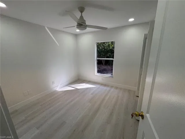 Spare room featuring light wood-style floors, ceiling fan, and recessed lighting