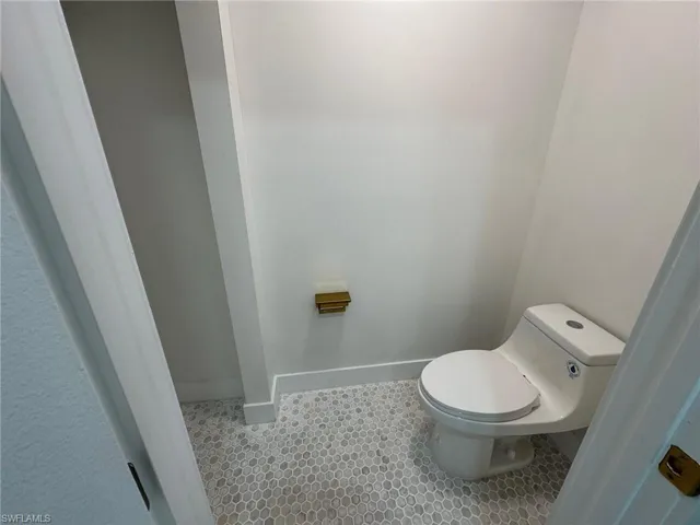 Bathroom featuring baseboards and toilet