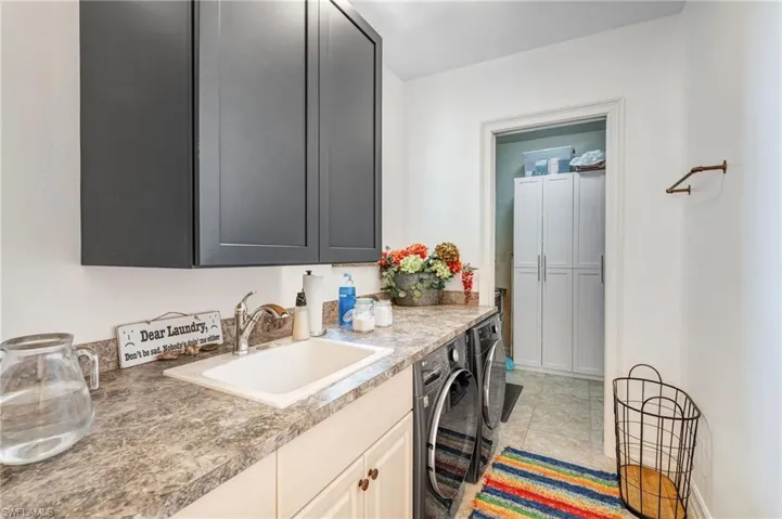 Laundry room featuring cabinet space, washer and dryer, and light tile patterned floors