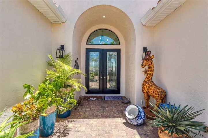 Entrance to property featuring stucco siding and french doors