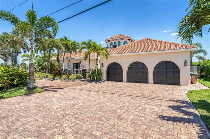 Mediterranean / spanish-style house featuring an attached garage, decorative driveway, stucco siding, and a tiled roof