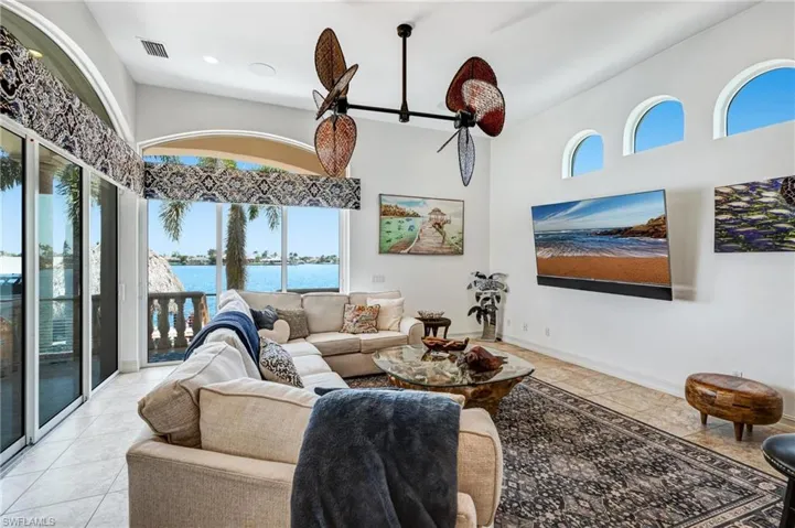 Living area with light tile patterned floors and a high ceiling