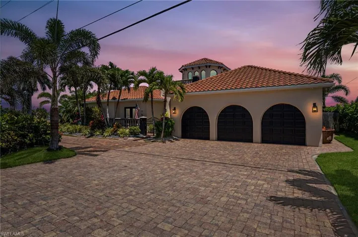 Mediterranean / spanish-style home featuring an attached garage, decorative driveway, stucco siding, and a tile roof