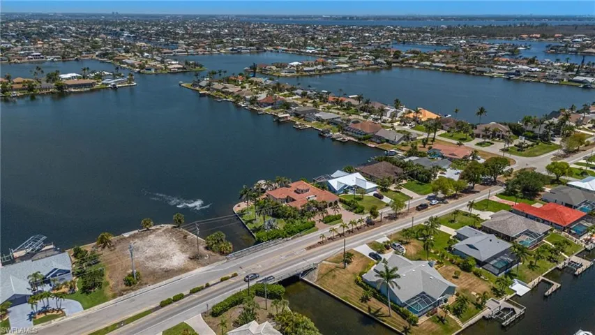 Aerial view of property and surrounding area featuring nearby suburban area and a nearby body of water