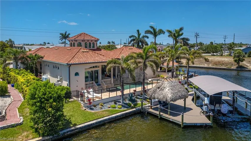 Dock area with a water view, boat lift, and a patio area
