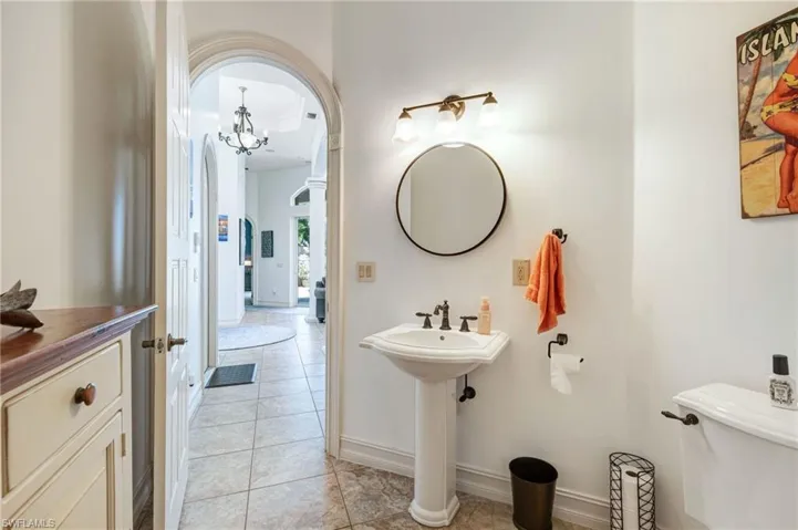 Bathroom with light tile patterned floors and a chandelier