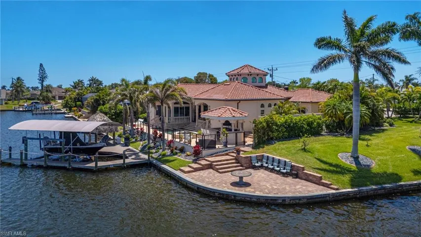 Dock area with a water view, a gazebo, a lawn, a patio area, and boat lift