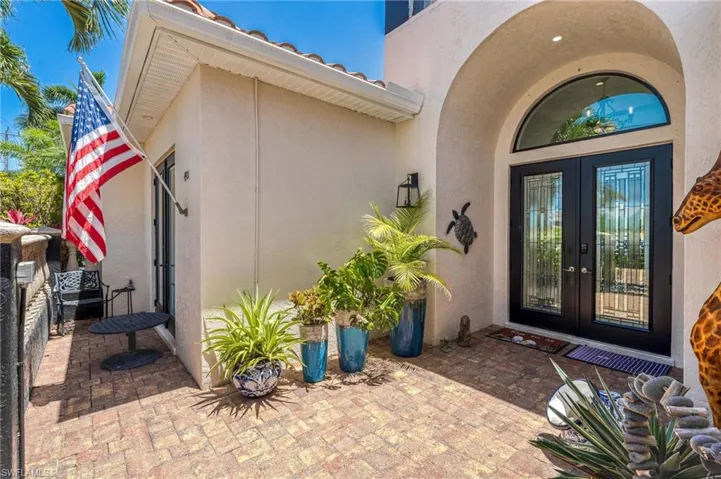 View of exterior entry with stucco siding and french doors