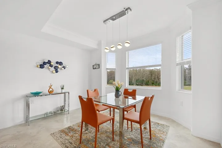 Dining space featuring ornamental molding and light tile patterned floors