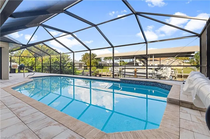 View of swimming pool with a pool cage