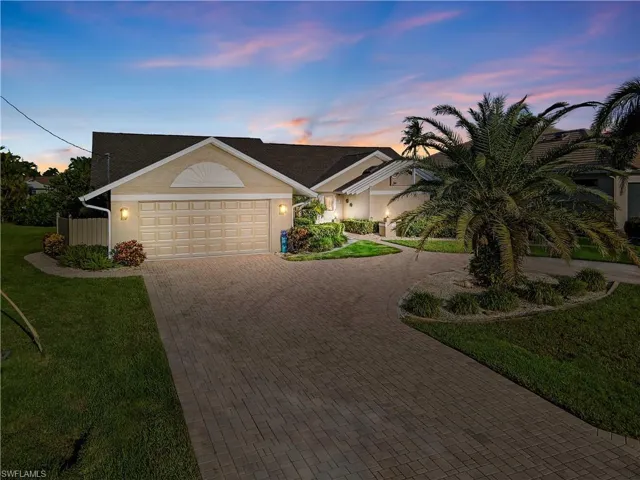 Ranch-style home featuring a yard and a garage