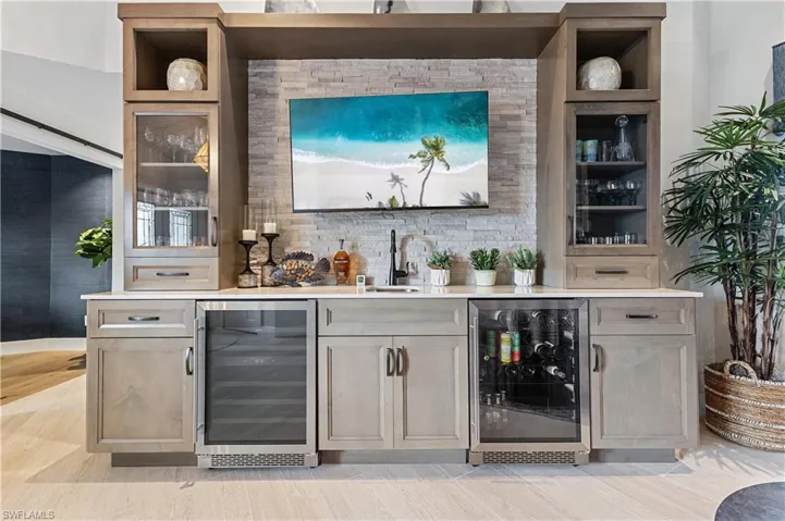Wet bar with built in shelves, wine cooler, and sink