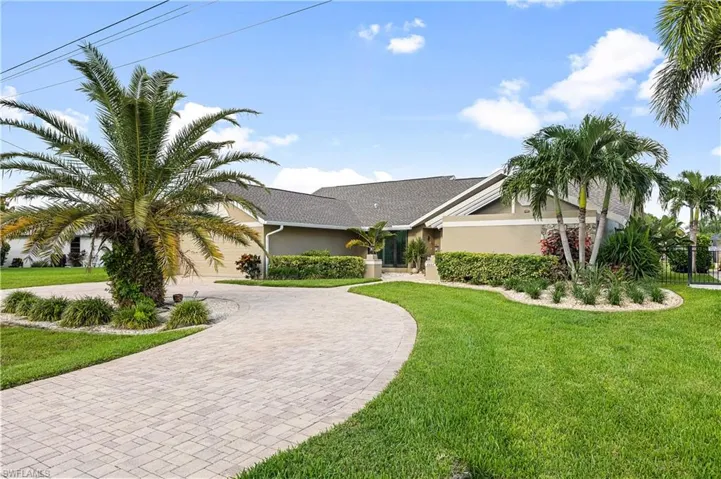 View of front of property featuring a garage and a front lawn