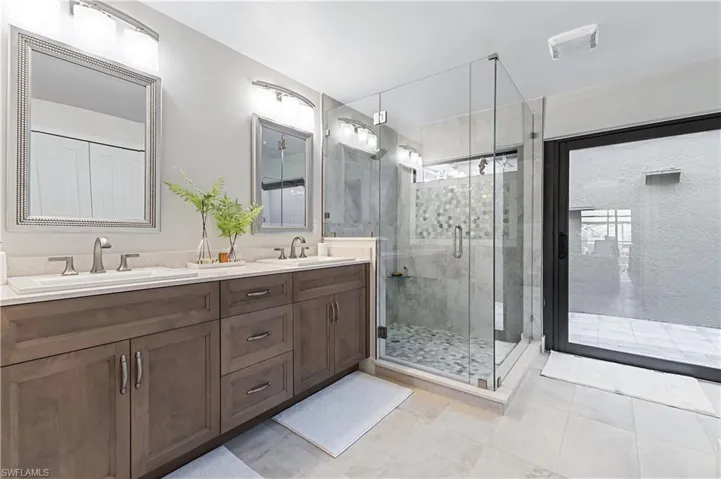 Bathroom with tile patterned flooring, walk in shower, and vanity