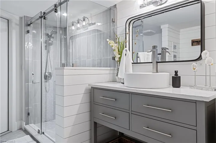 Bathroom with tile walls, vanity, and an enclosed shower