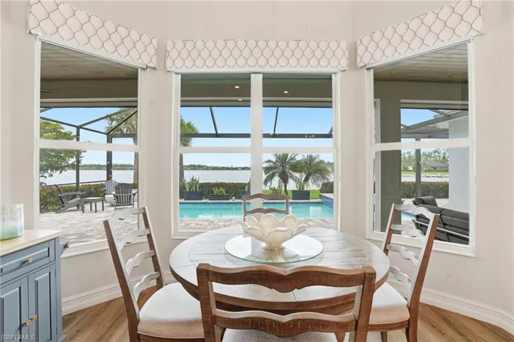 Dining area with bay window offering expansive water and pool access