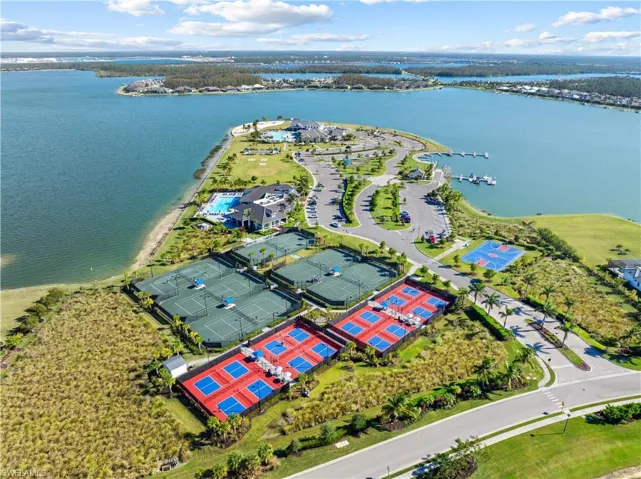 Expansive waterfront community featuring multiple tennis courts, pickleball courts, a basketball court, a large swimming pool, and a private marina with boat slips