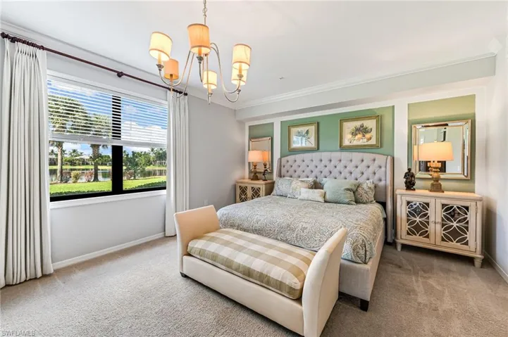 Carpeted bedroom featuring ornamental molding and a chandelier