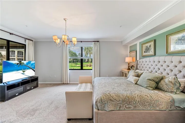 Bedroom featuring an inviting chandelier, carpet flooring, and ornamental molding