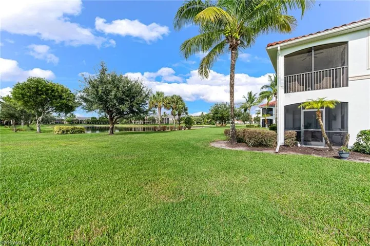 View of yard with a water view and a sunroom