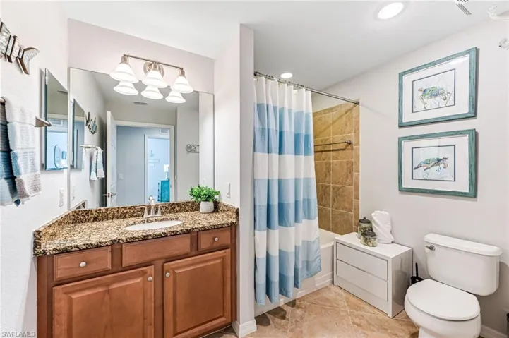 Full bathroom with shower / tub combo, vanity, toilet, and tile patterned floors