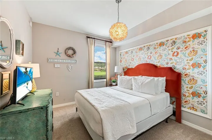 Carpeted bedroom with a notable chandelier