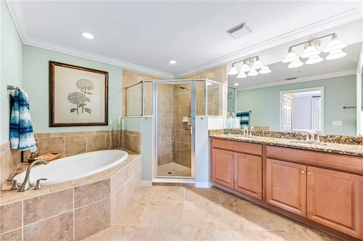 Bathroom with vanity, crown molding, separate shower and tub, and tile patterned floors