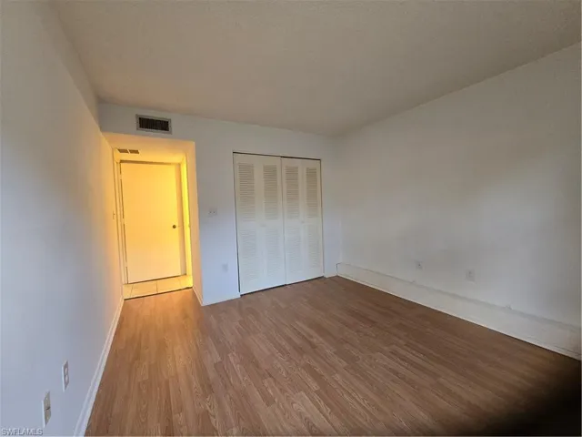 Unfurnished bedroom with a closet and hardwood / wood-style floors