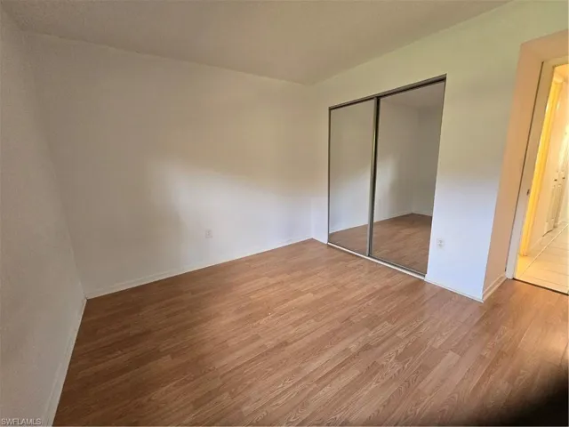 Unfurnished bedroom featuring a closet and hardwood / wood-style floors