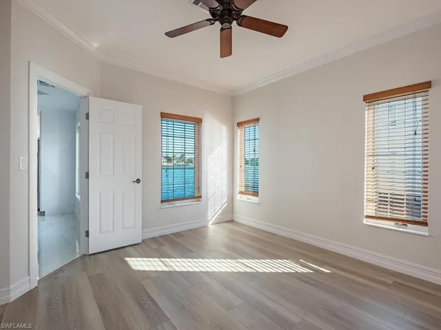 Unfurnished room with ceiling fan, crown molding, and light hardwood / wood-style flooring