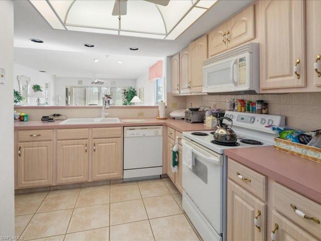 Kitchen has refaced cabinets, fan and tiled flooring.