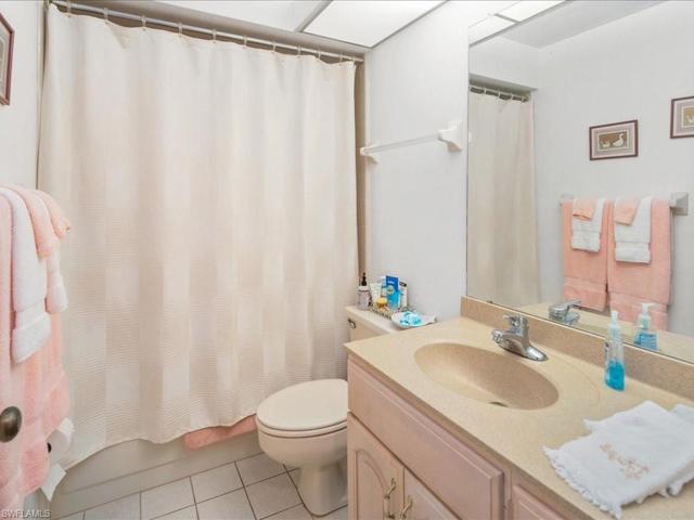 Guest bath features tub and shower, vanity with single sink and medicine cabinet.