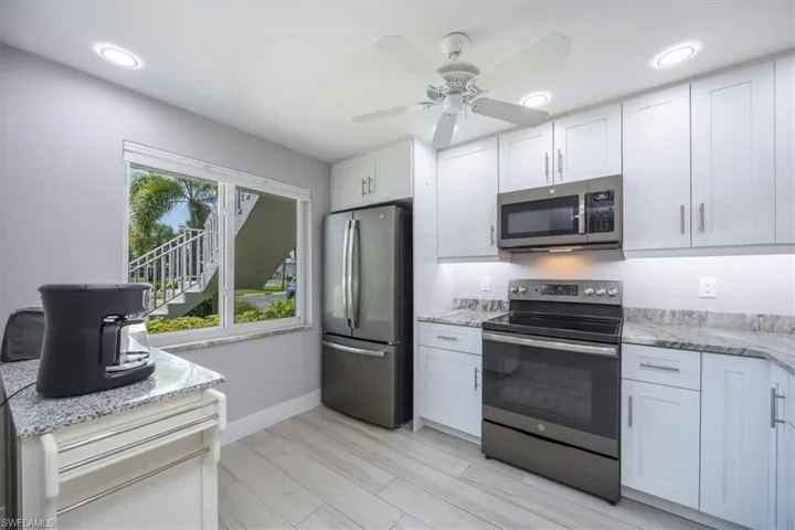 Kitchen featuring appliances with stainless steel finishes, white cabinetry, and ceiling fan