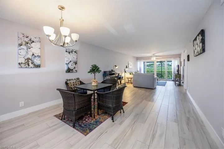 Dining area featuring ceiling fan with notable chandelier and light wood-type flooring
