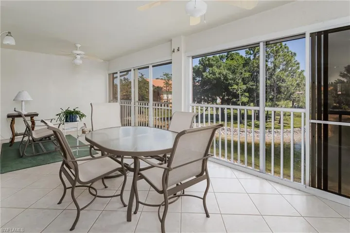Screened patio featuring tile flooring and ceiling fans