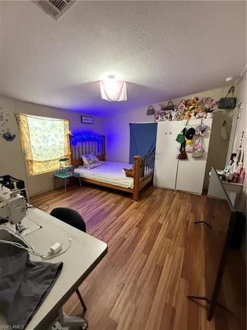 Bedroom featuring light wood-style floors and a textured ceiling
