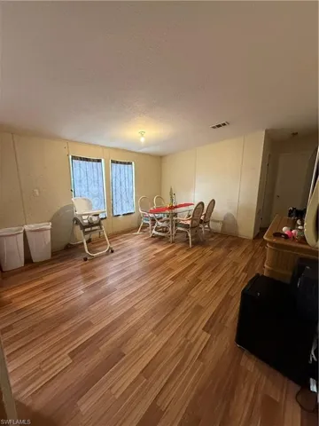 Dining space featuring wood finished floors and a textured ceiling