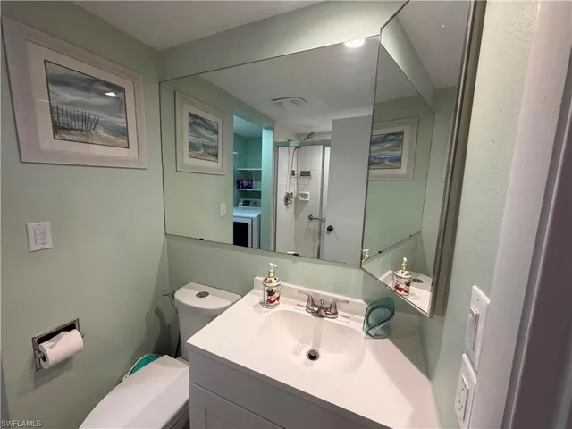 Vanity with a white sink and chrome faucet, set against light green walls
