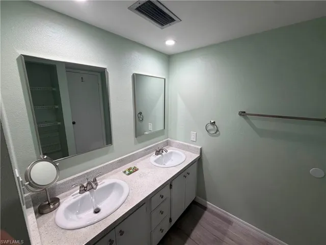 Double vanity featuring oval sinks, brushed nickel faucets, and a speckled countertop
