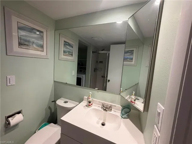Bathroom vanity featuring an integrated sink, polished chrome faucet, and a large wall-mounted mirror